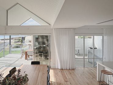 The use of Innova’s weatherboards and high raked ceilings enhances the ocean views and creates a seamless connection between inside and out