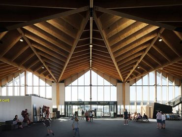 The timber structure forming the roof captivates with natural warmth, texture and scale
