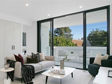 The living area features a configuration of Paragon stacking doors coupled to a louvre window spanning over 3.6m wide 