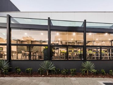 The stacking glass windows wrap the exterior of the expansive alfresco space