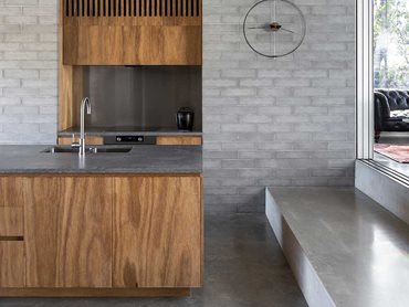 The timber walls and joinery complement the concrete and cement sheet interior 