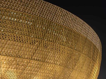 Triangular openings on the facade visually reinforce the bowl’s structural diagrid and form a perforated screen 