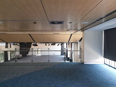 This ceiling addresses the acoustics across the wide area of the space. SUPAFINISH Black solid strips and returns are also featured.