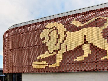 The Flexbrick screen featuring the Brisbane Lion is made from 3500 gold stainless steel tiles, and is surrounded by terracotta tiles 