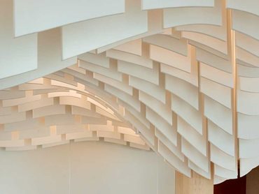 The acoustic baffles are custom cut to specific dimensions for an undulating wave-like aesthetic