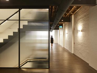 The office retains the original steel beams, timber flooring and exposed brickwork in the adaptive reuse project
