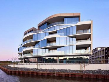 The semi-circular lakefront site is optimised through the clever use of angled panels of Alspec’s premium glazing systems 