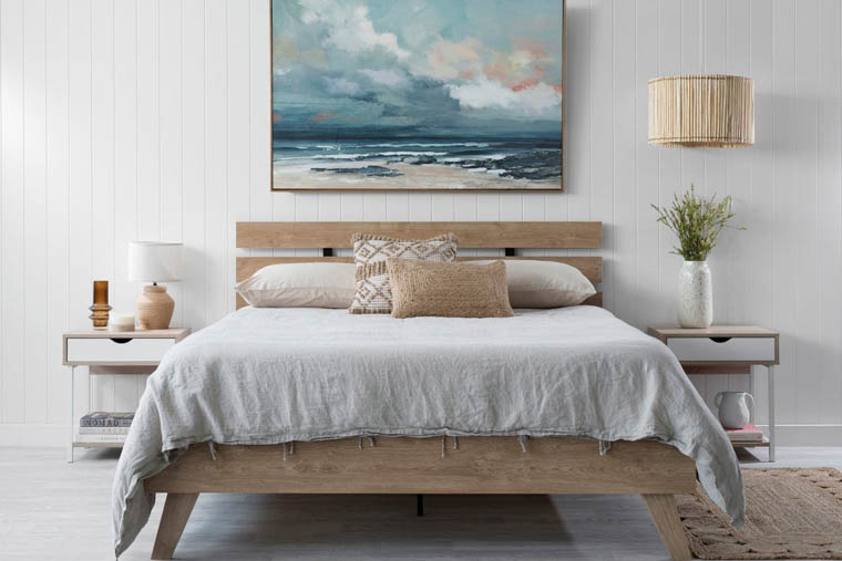 queen bed with ocean art and linen bedspread natural aesthetic