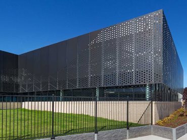 The ripple-patterned perforated sheet metal facade has an undulating effect