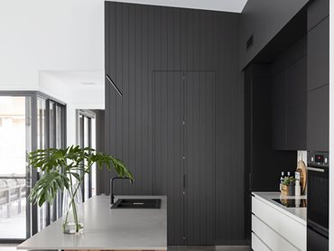 The interior design aesthetic is sleek and modern with a strong palette of black, charcoal and white