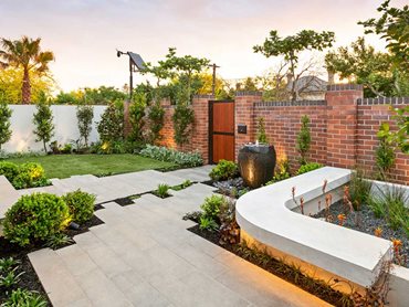 Flanked with soft lawn to the right, the paving continues towards the rain garden