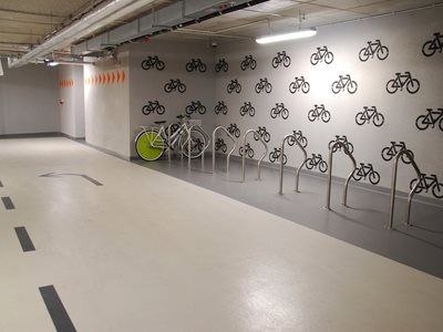 Detail of interior bike rack station with floor and wall wayfinding systems 