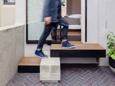 The materials palette includes mild steel, recycled timber floorboards, concrete, and herringbone brick facing tiles. 
