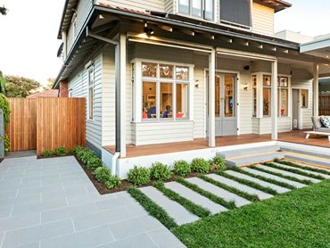 Step down from the veranda to follow a pathway of cool grey concrete steppers through the garden