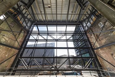 One of the 16 metre high boundary brick walls of the boiler house was removed to allow for an easier internal demolition, refurbishment and construction process and was replaced by a new efficient clear span portal frame solution. Photography by John Gollings