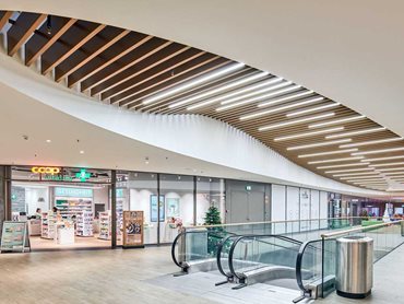 POLYLAM vertical baffle ceiling creates a visual highlight by complementing the curving shape of the building layout