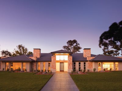 Front facade view of large modern home with terracotta roof tiles