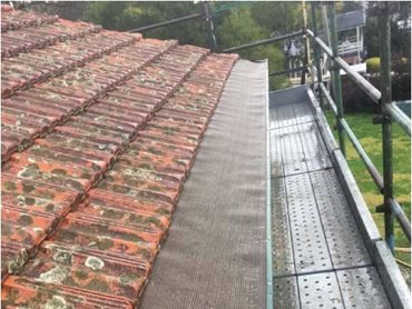 A workable scaffold system with our gutter guard installed on the roof. Note there are 3 different safety rails on the scaffold perimeter and the walkway continues around the roof corner