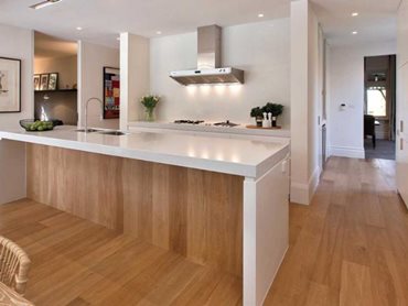 One can create a seamless transition from a timber floor to a white benchtop by matching the joinery to the floor