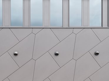 Anthracite EQUITONE [natura] panels, cut into simple geometric shapes, clad the building