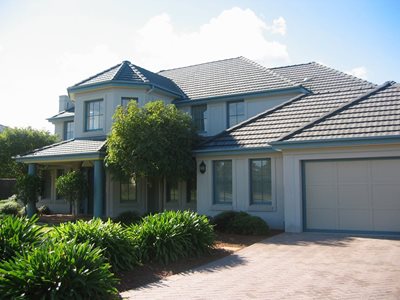 Exterior side view of multi-storey home with concrete roof tiles 