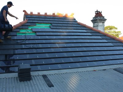Progress image of solar tiles being assembled on roof