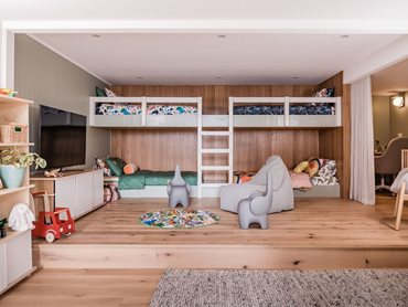 The kids' room  juxtaposes warm wood flooring and wall panels against a white Gyprock ceiling