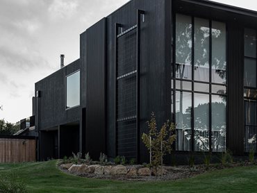 The charred black timber cladding is paired with timber look Ever Art Wood battens in Burakku Erumu