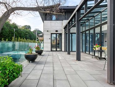 The large expanse of paving wrapped around this impressive residence features the cool grey tones of Anston Newham. 