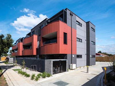Commercial building facade with through coloured fibre cement