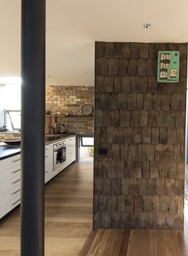 The interior linings are a mixture of materials from the previous cottage. The old shingles are used in a feature wall, the weatherboards on the front wall and the frame is made into shelves throughout the house. Photography by Brett Boardman
