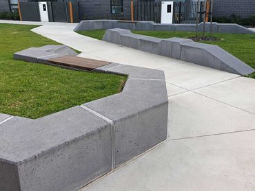 The concrete bench seats are produced in sleek charcoal concrete with an exposed aggregate finish