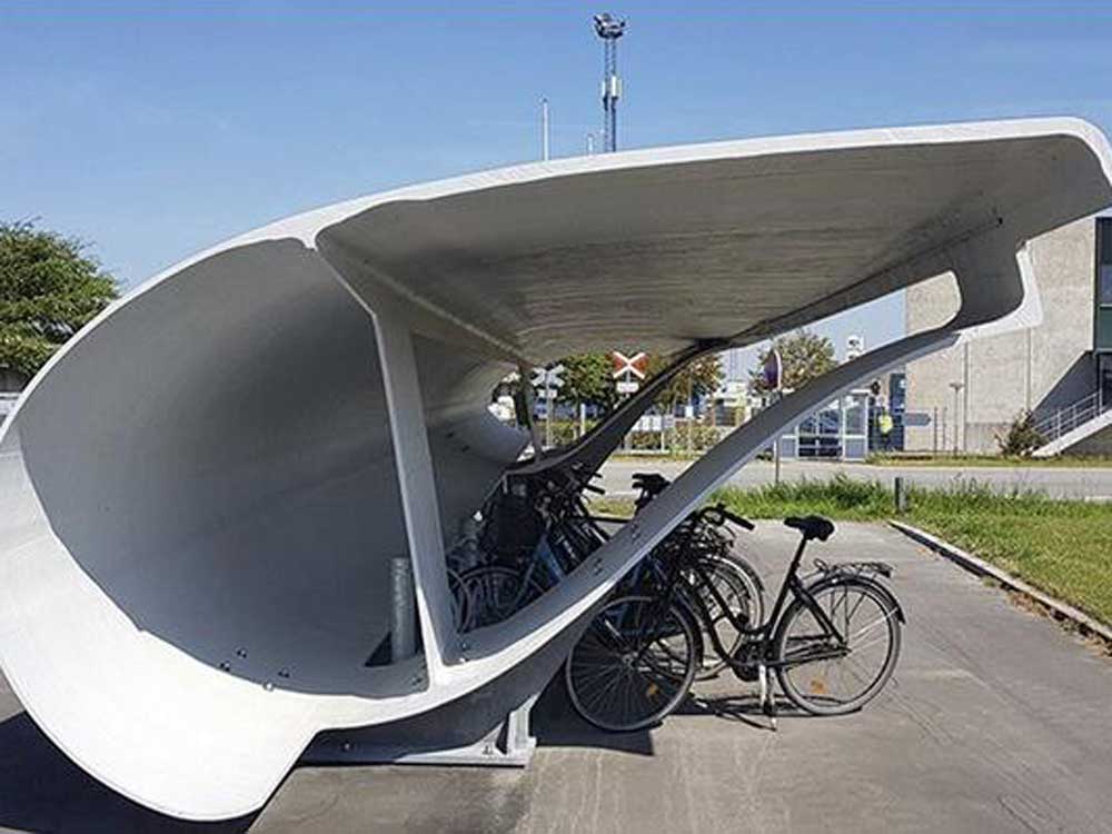 A bike shelter repurposed from a discarded wind turbine blade