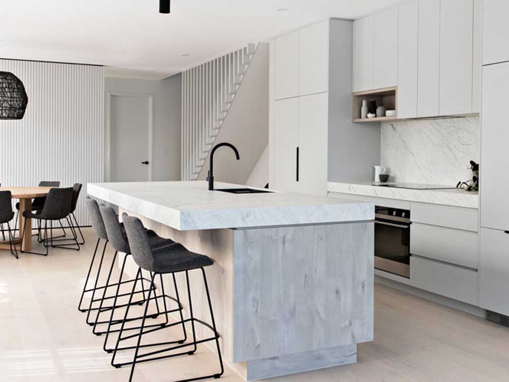Mixing timber finishes and solid colours in kitchen design is a popular trend