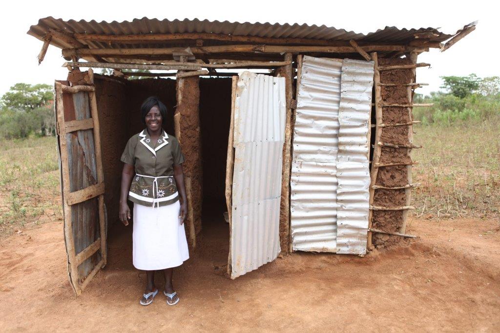Kenyan-woman-standing-in-front-of-the-toilet-C-UNICEF-Kenya-2015-Vidyarthi.jpg