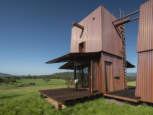 Overlooking the Pacific Ocean amongst the lust green paddocks of Berry, sit two tiny copper towers. Designed to provide the essential requirements for shelter – a bed, a deck, a fireplace, and a bathroom.