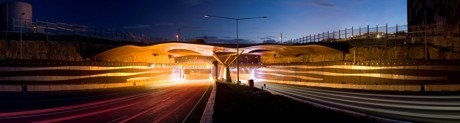 At night the canopies are washed with coloured light which enhances the copper tones of the metal panels. (Image courtesy RiverCity Motorway Group.)